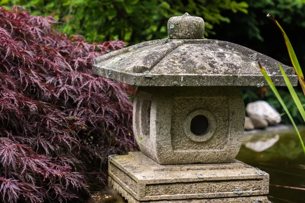 Large stone lantern with red acer tree in background