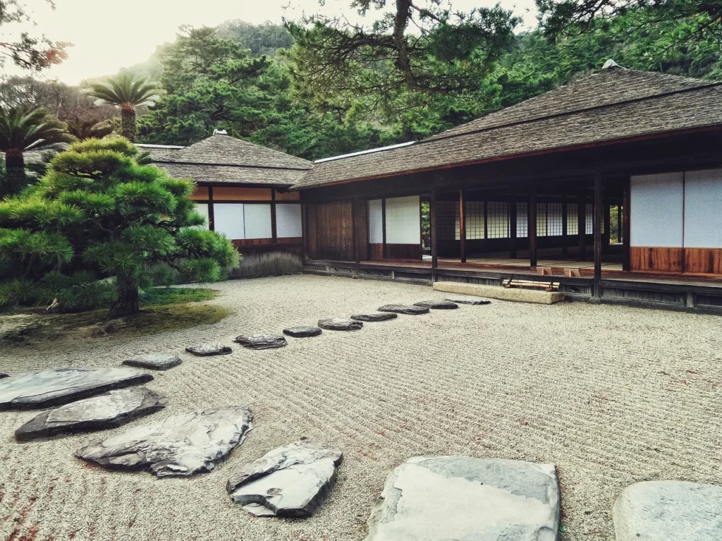 Zen garden with maple tree in far left corner in front of Japanese traditional building