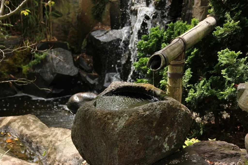 bamboo water feature above a large stone