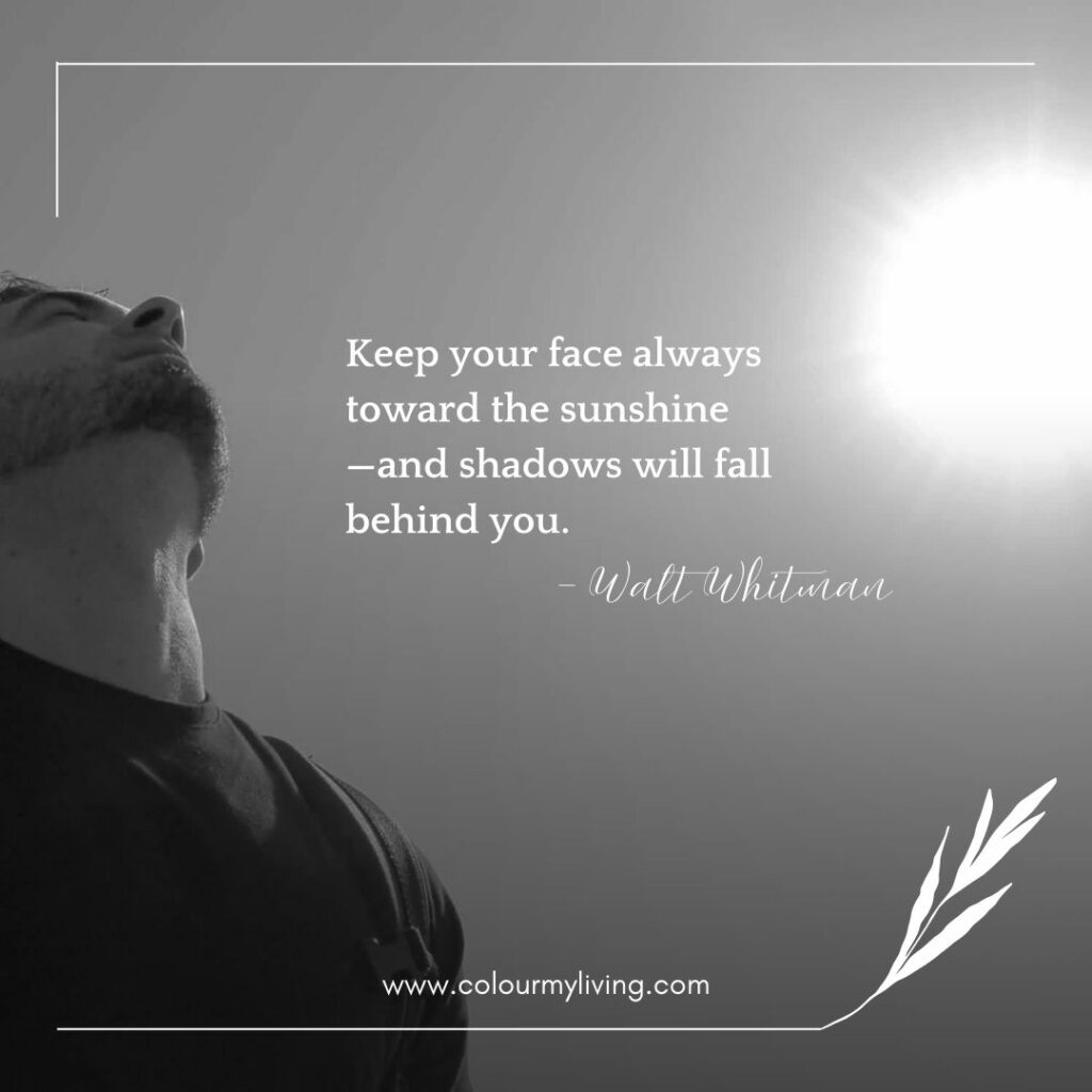 Image: shot from lower bottom of a man facing the sun. Quote “Keep your face always toward the sunshine—and shadows will fall behind you.” – Walt Whitman